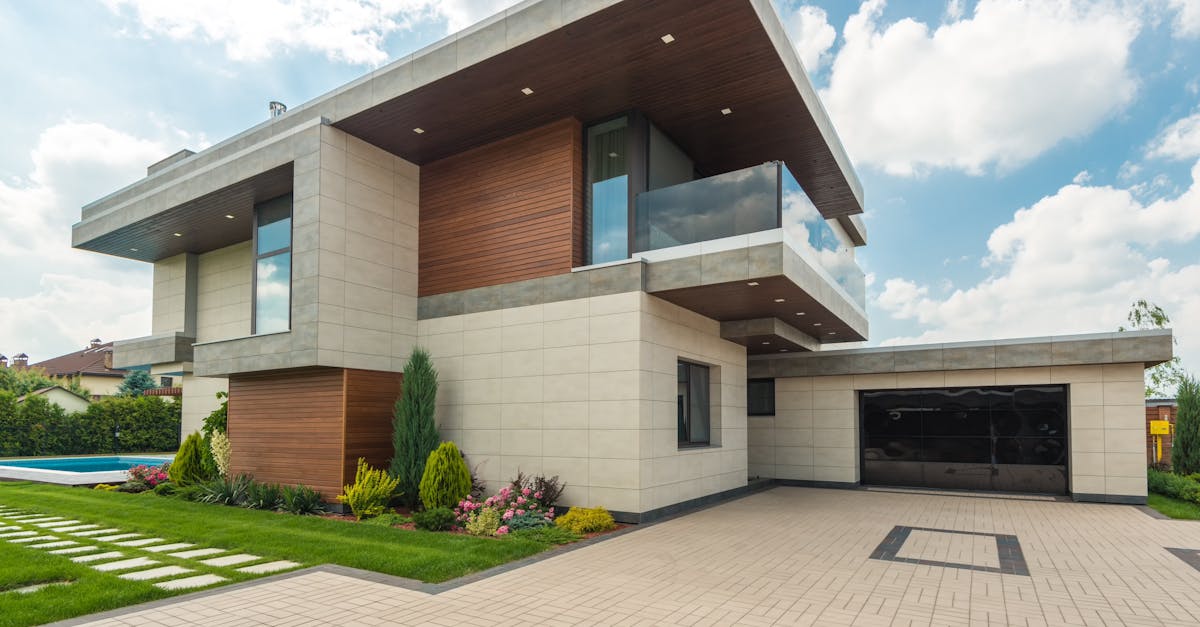 Contemporary luxury house with a sleek design, lush garden, and blue sky.